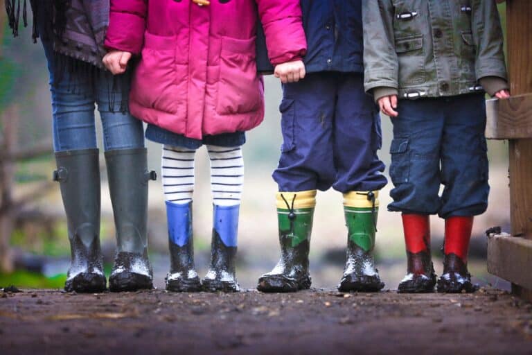 Children standing outdoors wearing colorful rain boots, symbolizing hope and recovery in drug detox and rehab programs.